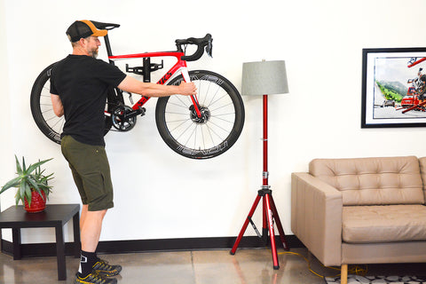 Person hanging a bike on a wall for storage.