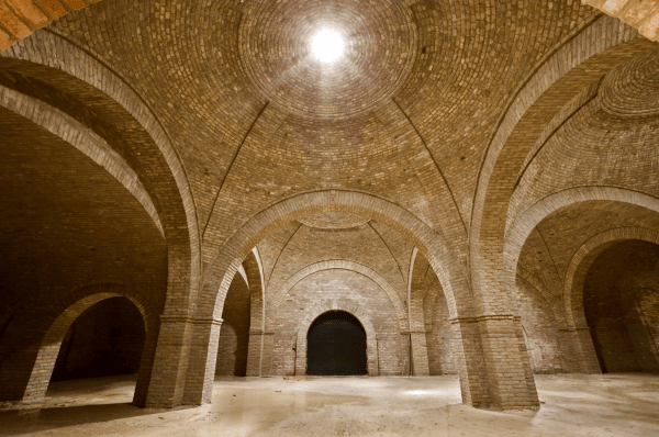 suspension luminaire au plafond d'une très grande cave voûtée en pierre