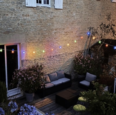 guirlande LED extérieure multicolore qui éclaire une terrasse en bois 
