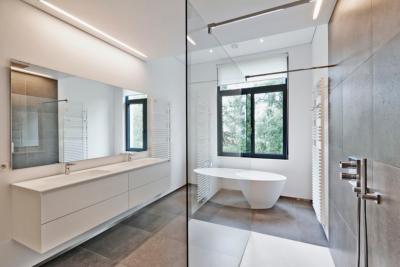 miroir de salle de bain blanche et contemporaine éclairé par une réglette lumineuse placée au-dessus