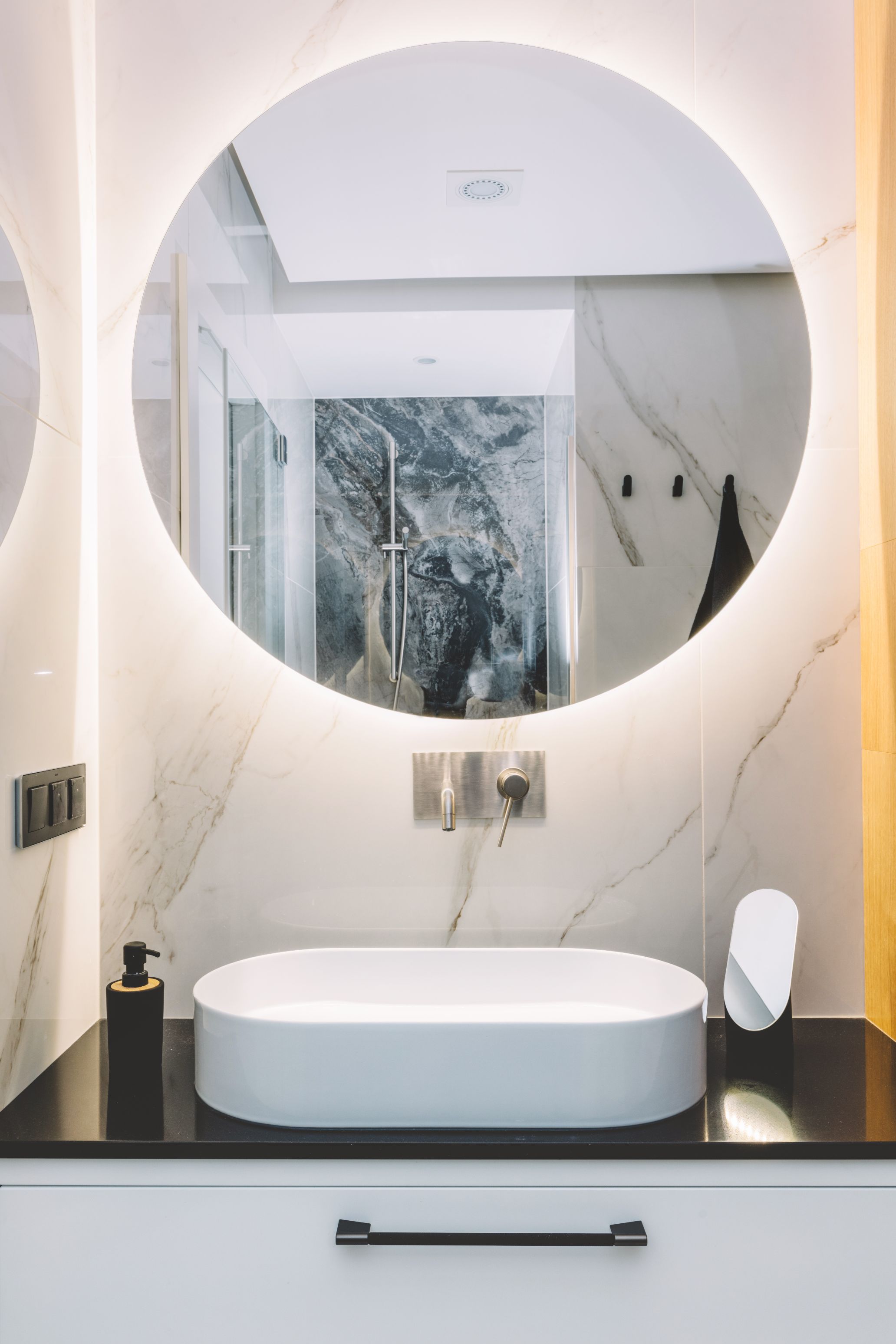 ruban LED blanc lumineux autour d'un miroir de salle de bain rond