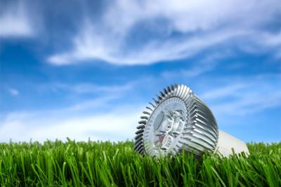 ampoule LED posée sur l'herbe sur fond de ciel bleu