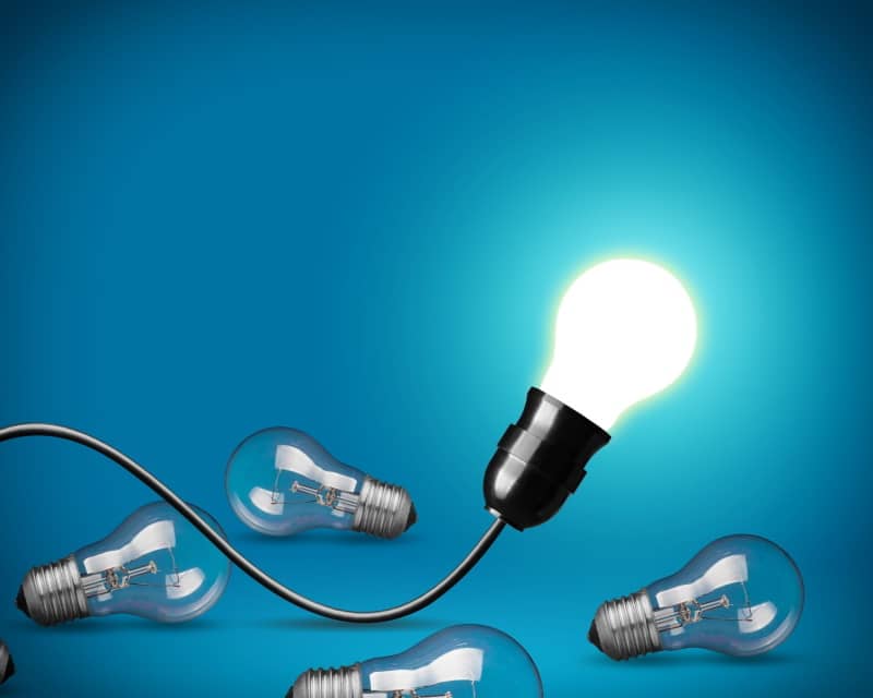 ampoule LED lumineuse dans douille sur câble noir, avec fond bleu