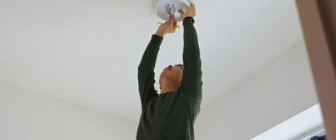 Homme qui installe une applique LED au plafond