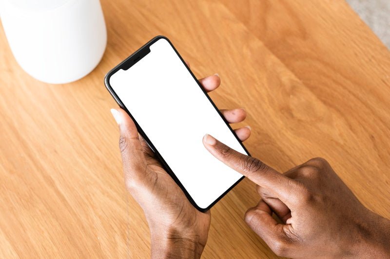 objet connecté : mais d'une femme sur un smartphone pour contrôler son appareil connecté