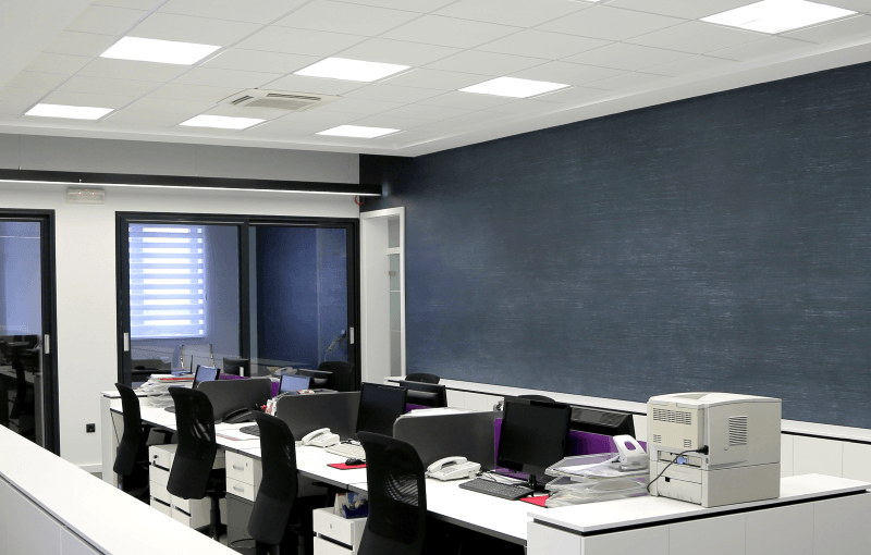 bureau collectif éclairé par des panneaux LED au plafond