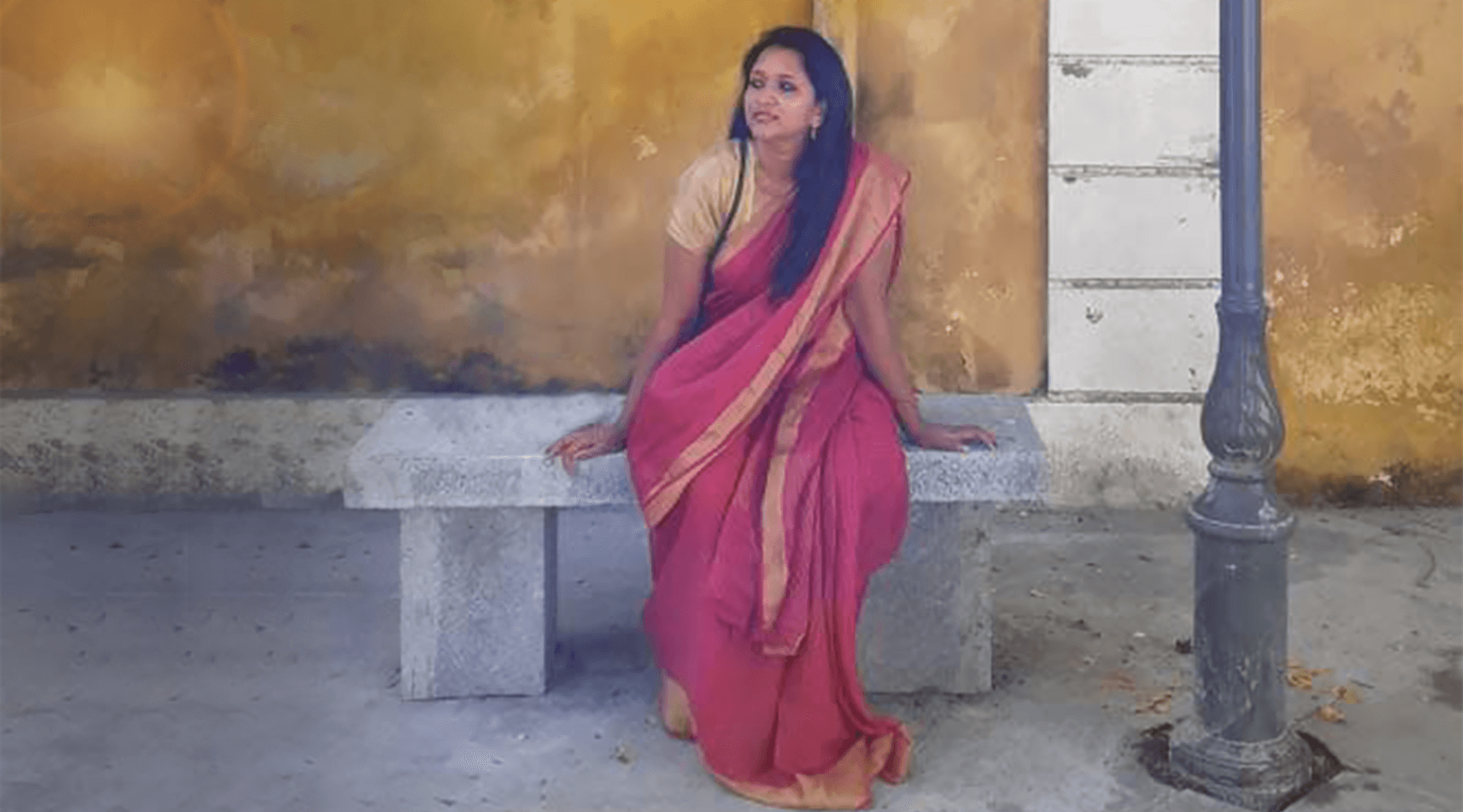 Founder of Seven Sarees Hema sitting on a bench in Pondicherry. 