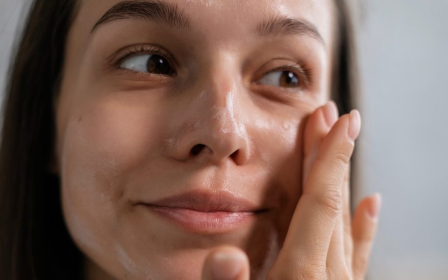 woman applies shea butter on her face