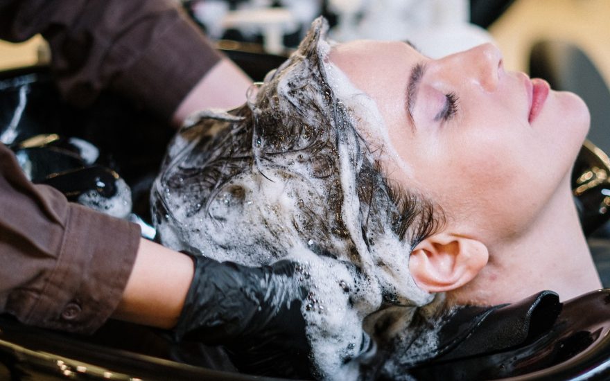 vrouw die met droog haar shampoo maakt