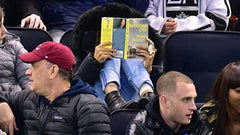 Sarah Jessica Parker reads a book at a hockey game.