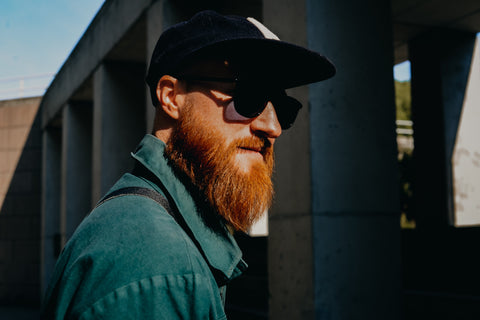 Man with beard wearing black baseball cap