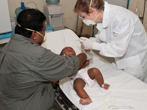 Baby with parent being examined by a nurse