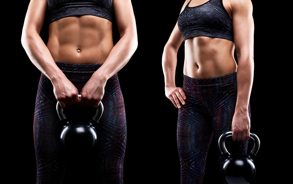 Woman showing abs while holding kettlebell