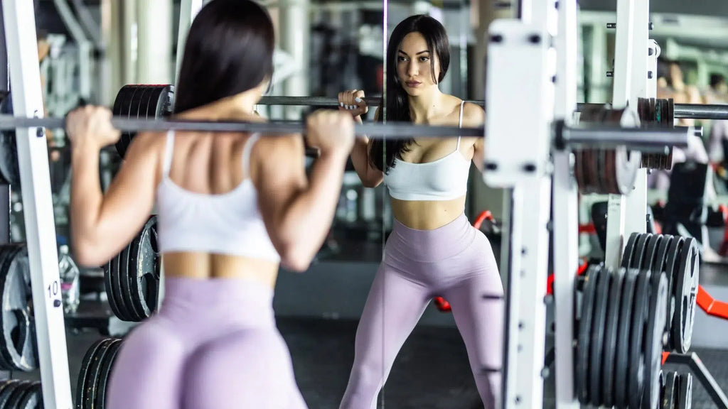 girl squatting in a power rack to grow a big butt