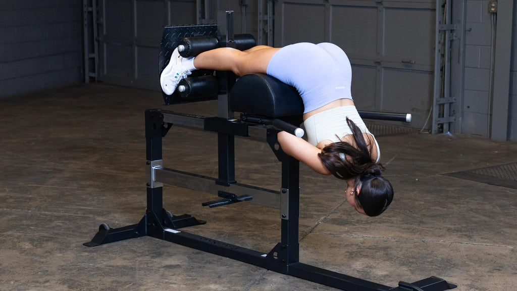 woman exercise on glute ham machine for a round butt