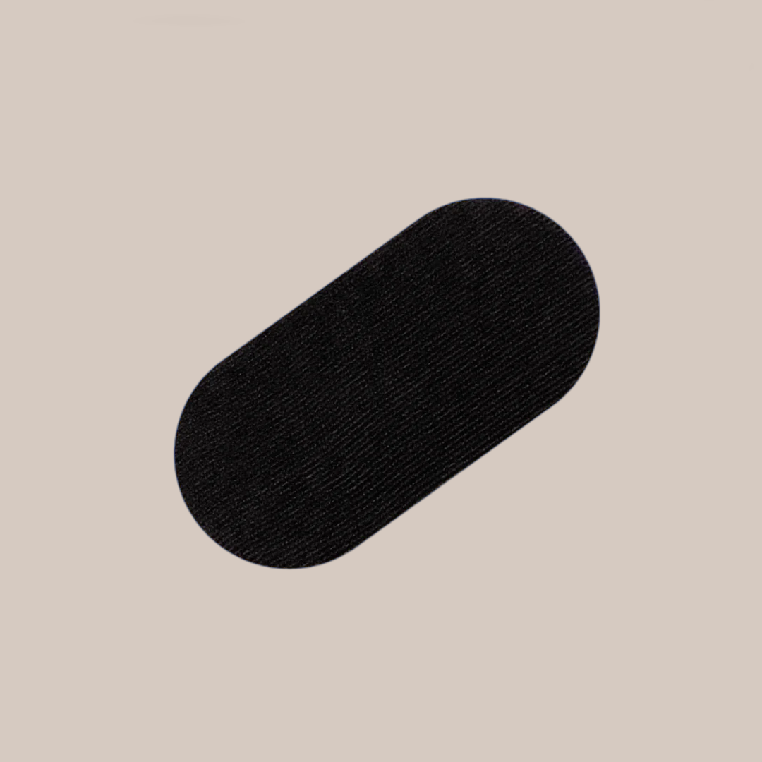 Et bilde av en sort munntape, en type klebemiddel brukt for å hjelpe til med å redusere snorking ved å oppmuntre nese-pusting, plassert mot en nøytral lysfarget bakgrunn.