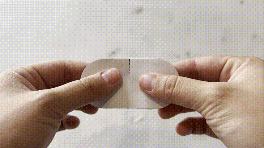 En GIF som viser hvordan man tar av papiret på munntapen for å vise den klistrete siden. Tapen brukes over munnen for å hjelpe folk å puste gjennom nesen når de sover