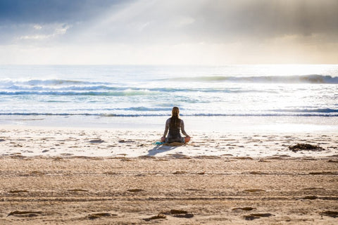 Girl sitting on the beach breathing