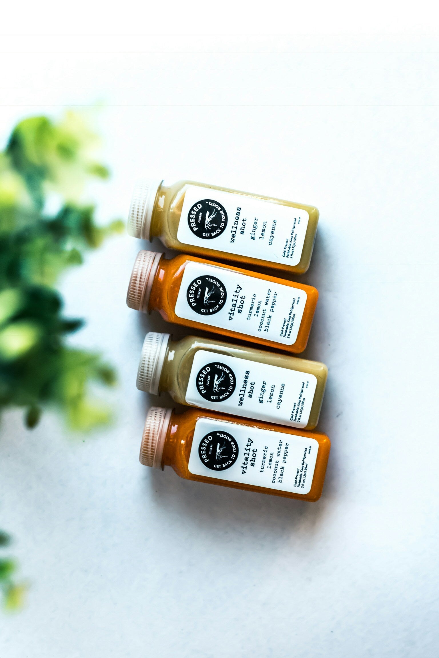 four different juices with black and white lables on a white background