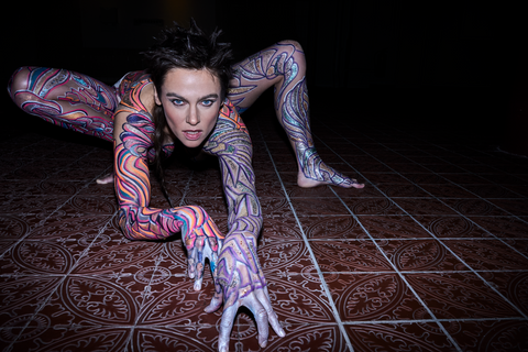 Image of Nina Burri, Contortionist and Body Painted by Johny Dar, Gracefully Posing on the Floor in Spider-like Contortion