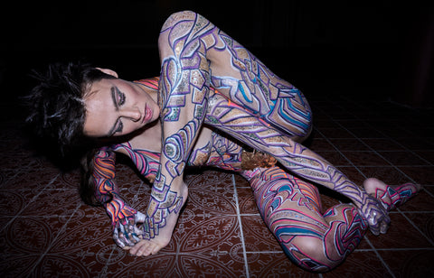Image of Nina Burri, the Body Painted Snake Woman, Striking a Pose on a Tile Floor