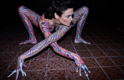 Image of Nina Burri, the Body Painted Snake Woman, Striking a Pose Like a Spider on the floor