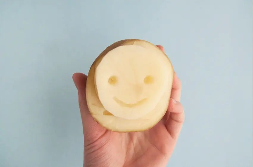 Carve smiley face into potato