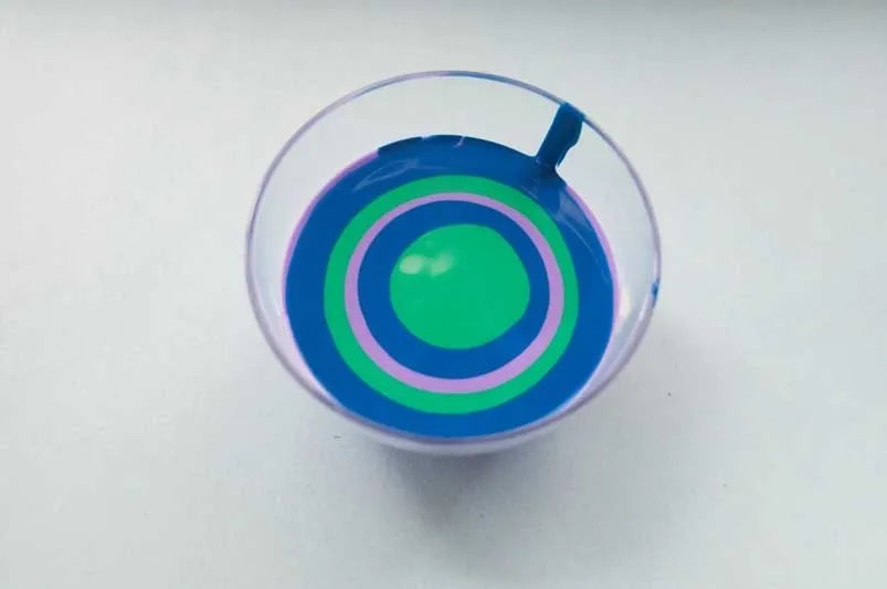 Pour paints into cup in bullseye pattern