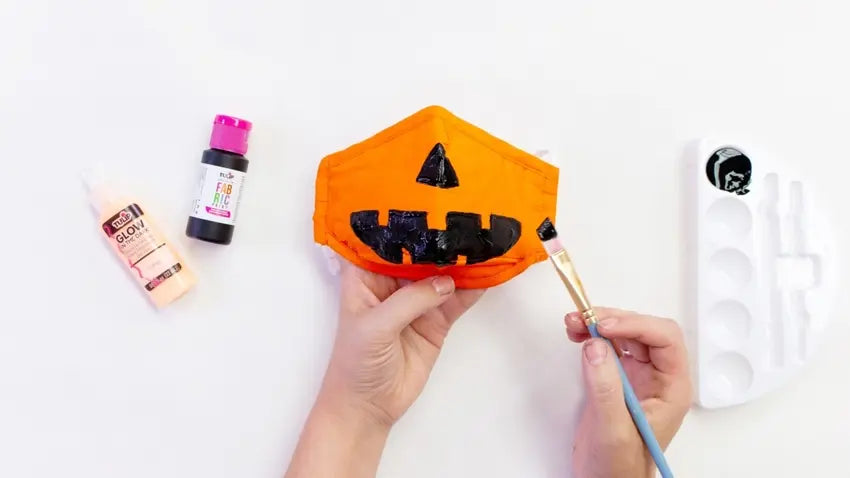 Use fabric paint to decorate your pumpkin mask