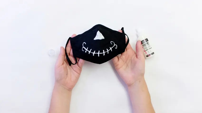Outline the skeleton face with Glow in the Dark Dimensional Fabric Paint
