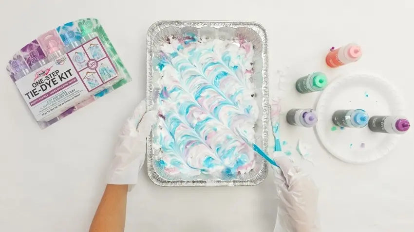 Apply dye to shaving cream and create marbled patterns with knife