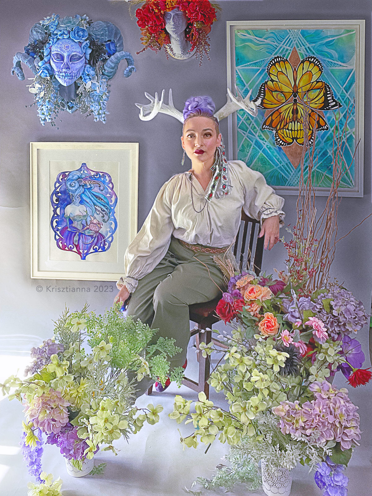 Krisztianna the artist sits in her studio amidst her flower materials and paintings