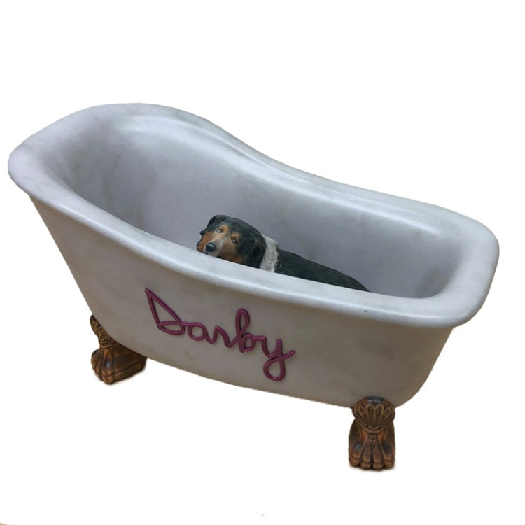 A custom ceramic pet urn that depicts a dog named Darby in a bathtub