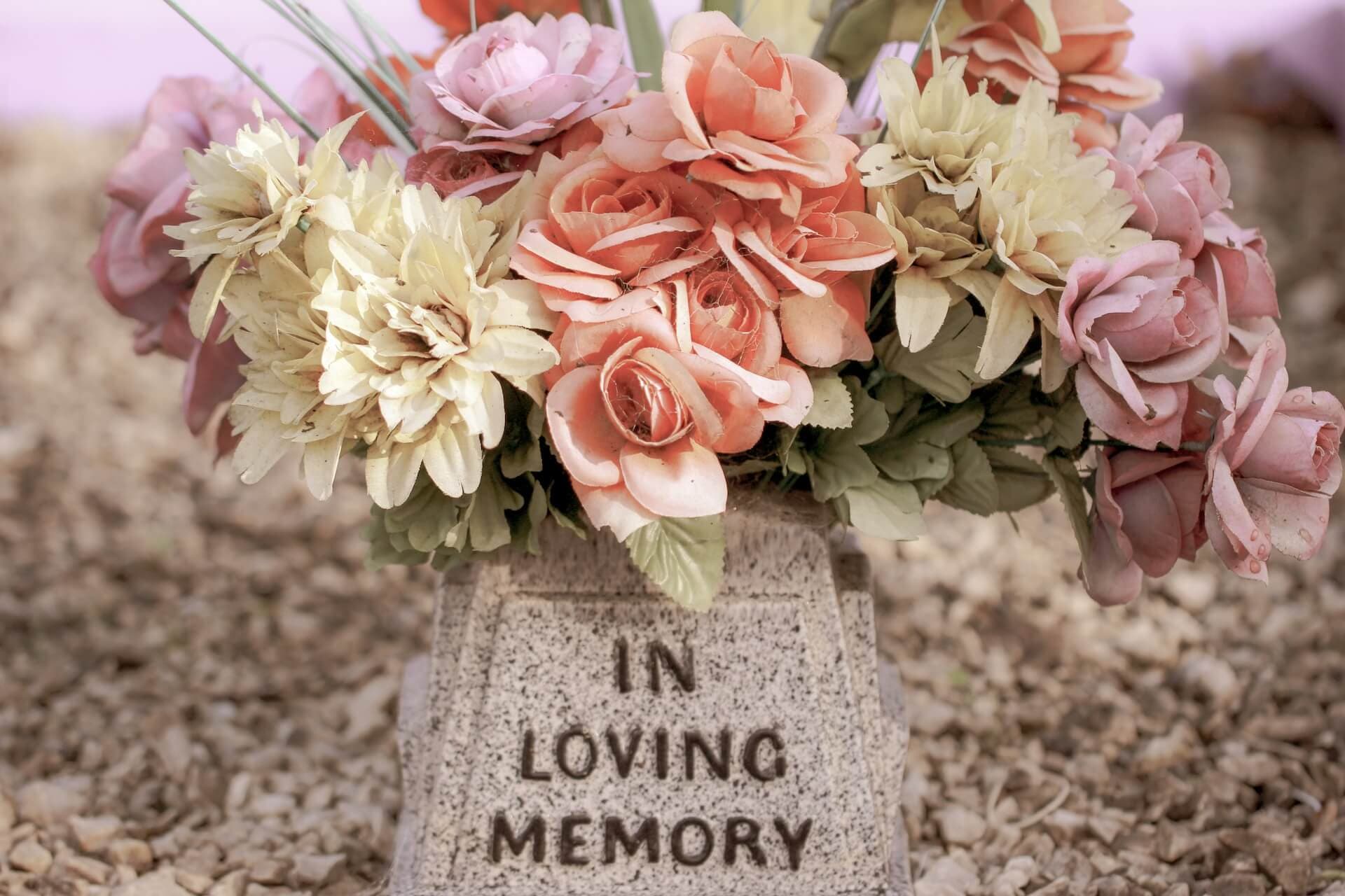 in loving memory tomb with colorful flowers