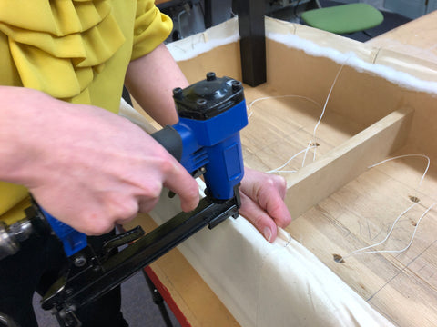 Using a pneumatic staple gun to recover an upholstery project