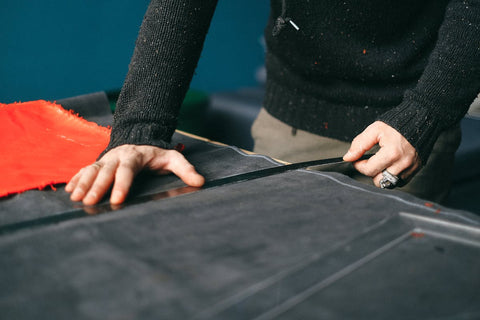 Man measuring fabric for cutting