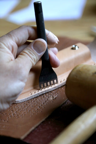 Using a stitching chisel to punch sewing holes in leather for leathercraft hobby