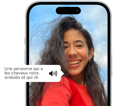 iPhone 15 affichant une annonce de VoiceOver décrivant une personne qui a les cheveux noirs ondulés et qui rit