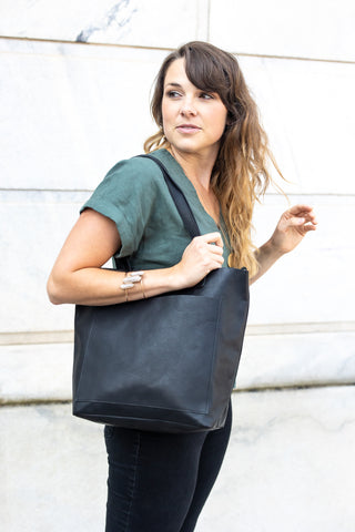 Woman holding black leather purse from MADE FREE