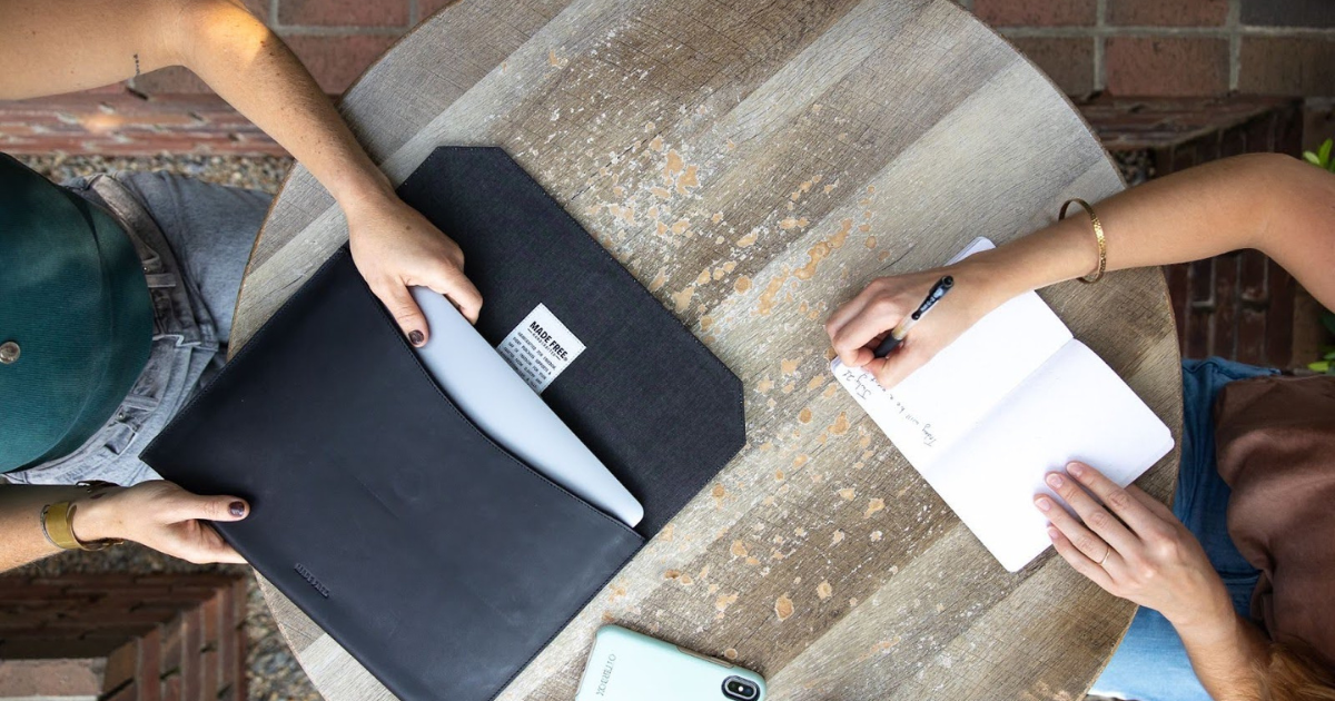 Woman using leather laptop sleeve to protect her computer