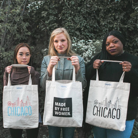 Women holding branded tote bag by MADE FREE