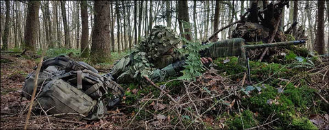 Image d'un militaire camouflée dans une forêt