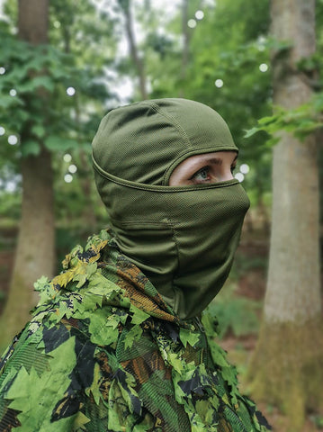Image d'une militaire portant une cagoule verte dans la forêt