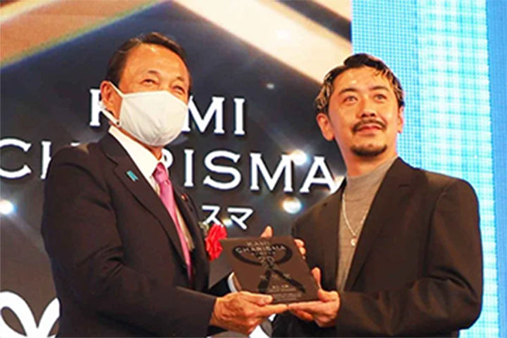 授賞式の様子。麻生太郎氏が朝日光輝に盾を贈呈している。KAMI CHARISMAアワード会場にて