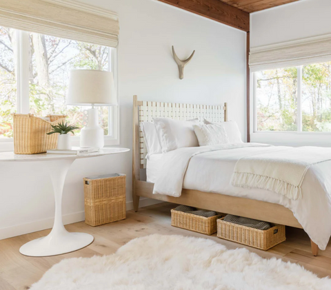 2 natural-colored underbed wicker baskets underneath a bed.