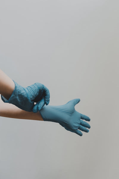 person pulling on latex gloves