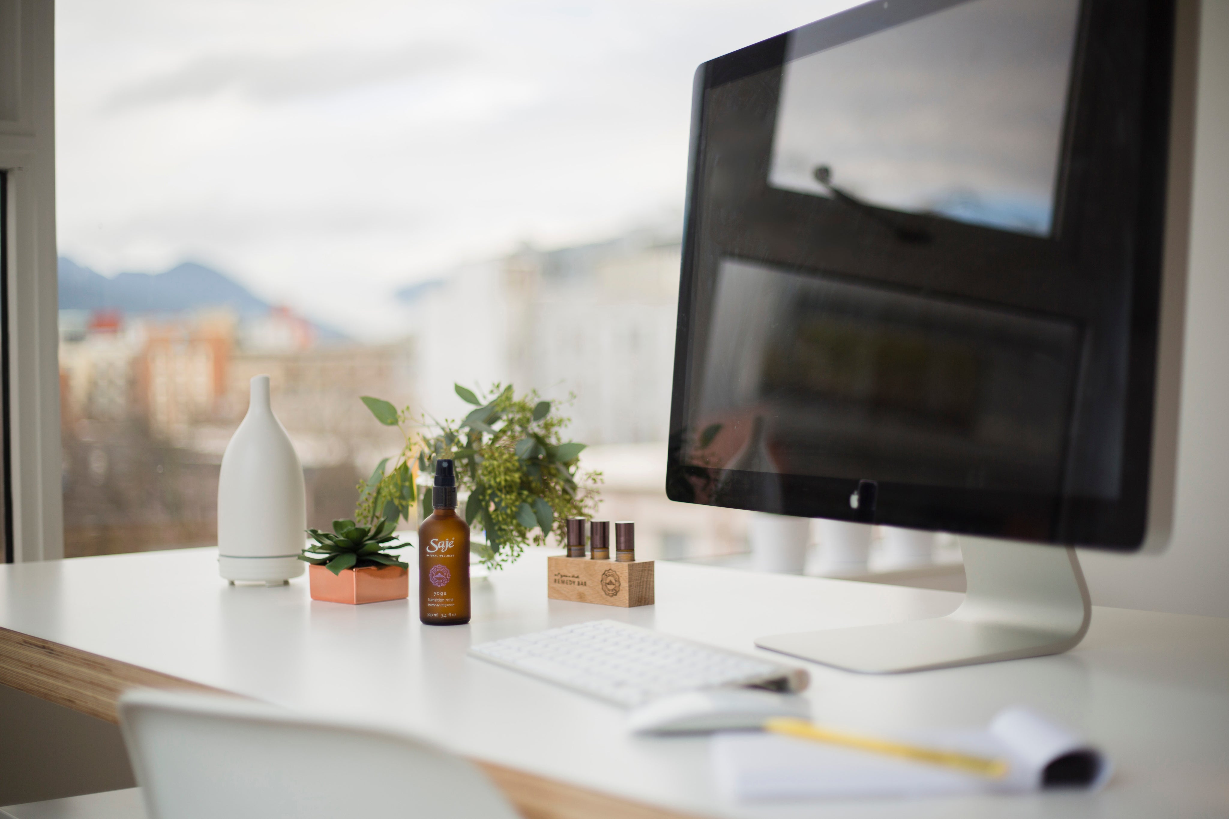 A desk with a monitor and Saje products on it