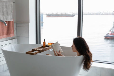 A woman reading in a white bath tub