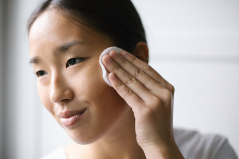 A woman using bare face makeup remover