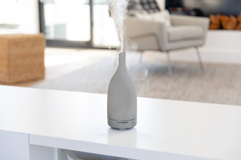 An aroma om diffuser misting on a white counter